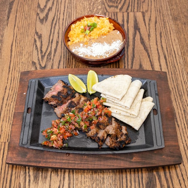 La Cocina's grilled steak fajitas with pico de gallo, lime, tortillas, rice, and refried beans.