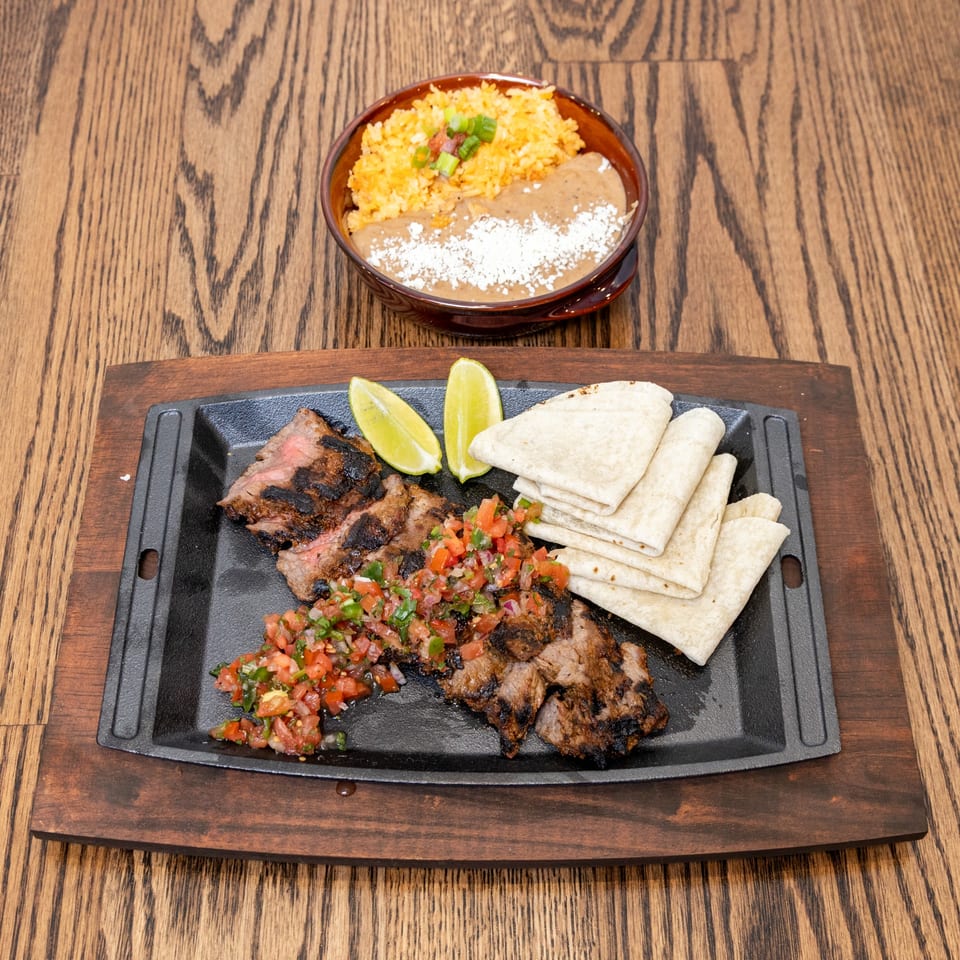 La Cocina's grilled steak fajitas with pico de gallo, lime, tortillas, rice, and refried beans.